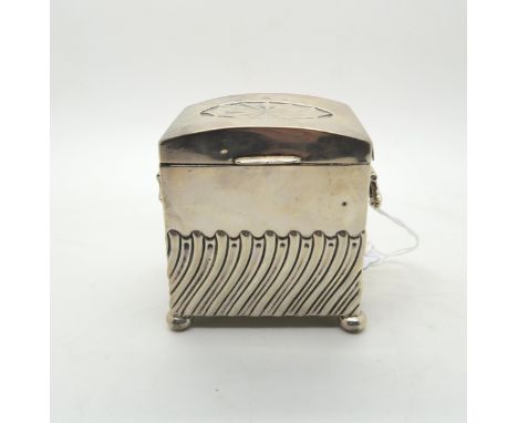 An Edwardian silver tea caddy, modelled as a chest, the body with waved fluted decoration, with two handles, on four bun feet