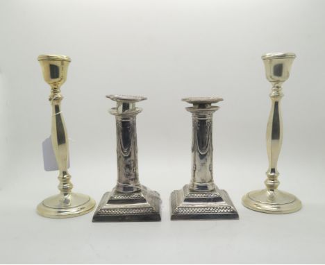 A pair of Edwardian silver candlesticks, the stepped square bases with scale motifs, supporting columns decorated with ribbon