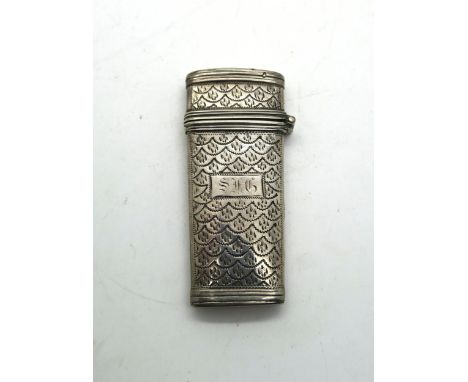 A silver etui, with bright engraved scale motif decoration surrounding an initialled rectangular cartouche, containing two to