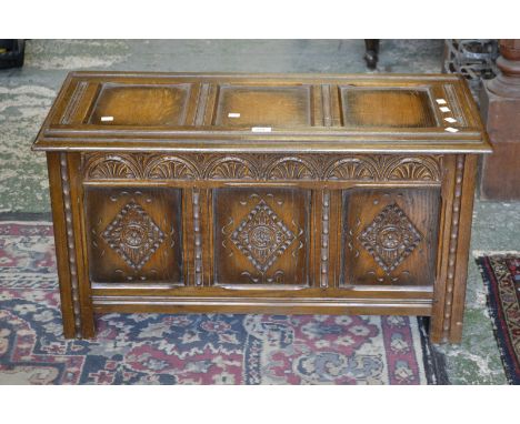 An oak blanket box, carved panel front