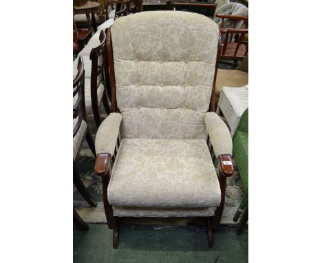 A contemporary fireside rocking chair. button back upholstery, spindled arms.
