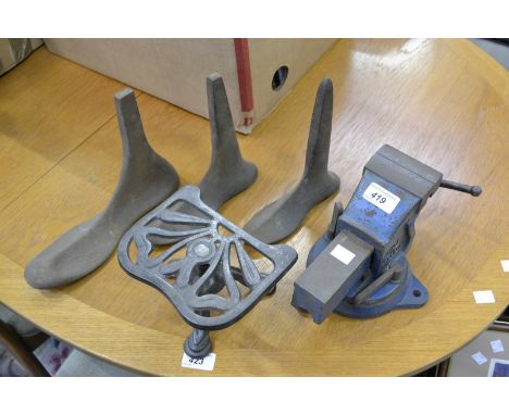 A cast iron trivet; a cast iron bench vice; a set of male, female and child shoe lasts