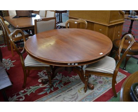 A Victorian mahogany tripod base dining table with three mahogany  balloon back dining chairs.