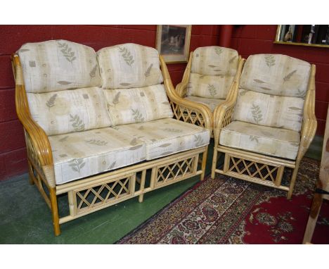 A cane conservatory three piece suite comprising two seat sofa and two armchairs.
