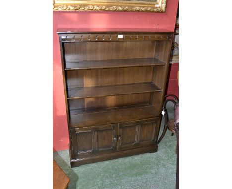 An Ercol bookcase, panelled doors to base