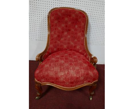 An early 20th century Edwardian walnut framed nursing chair, button red tapestry and front cabriole supports 