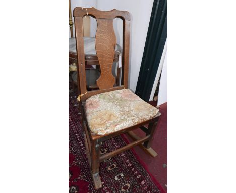 A Georgian oak rocking chair with splat back and squab cushion. 