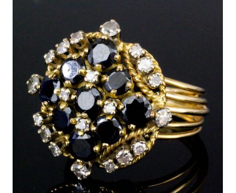 A gold coloured metal mounted sapphire and diamond cluster ring, set with nine old cut sapphires in lozenge pattern intersper