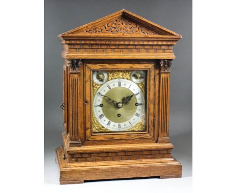 A late 19th Century German oak cased mantel clock, the brass dial with 5.75ins diameter silvered chapter ring with Roman nume