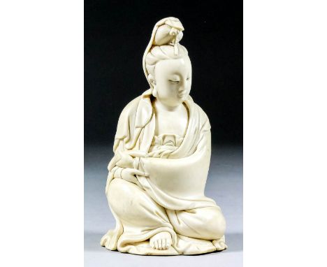 A Chinese carved ivory seated figure of Guanyin holding a scroll, 5.75ins (14.6cm) high (19th century) Note: Please be aware 