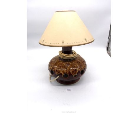 A brown glazed pottery lamp with cut out holes. 15 1/2" tall including shade.