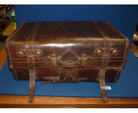 A vintage brown leather Trunk with tooled detail to the fastenings and marked "solid leather" to the front, lined with blue t