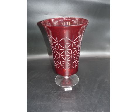 A large ruby vase with clear glass footed base, the body engraved with star style design.