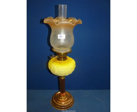 An oil lamp with a yellow glass reservoir, etched glass shade and clear chimney. 26" tall.