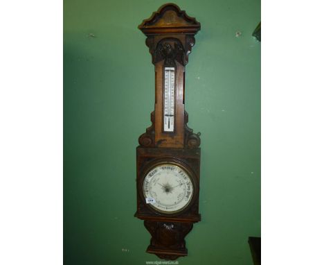 A large vintage mercury Aneroid barometer having carved decoration. Some splits to wood. 41" tall.