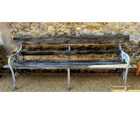 A garden bench with painted metal ends, decorated leaves, with wooden splats, 222 cm wide
