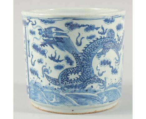 A LARGE CHINESE BLUE AND WHITE PORCELAIN BRUSH POT, decorated with dragons above stylised waves including an inscribed panel 