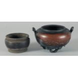 A CHINESE BRONZE TWIN HANDLE CENSER, with relief decoration of stylised waves and raised on three