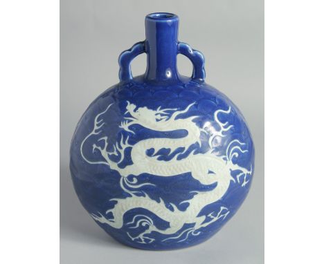 A CHINESE SACRIFICIAL BLUE AND WHITE PORCELAIN TWIN HANDLE MOONFLASK, with carved dragon and scale-form waves, 27.5cm high.