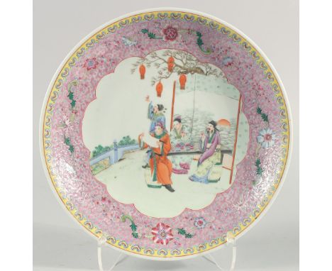 A LARGE CHINESE FAMILLE ROSE PORCELAIN DISH, painted with a central panel of figures in a garden with a enamel painted border