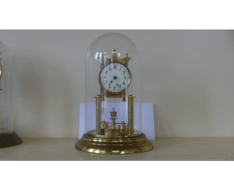An Anniversary clock, brass body and base with glass dome, Arabic numerals to dial 