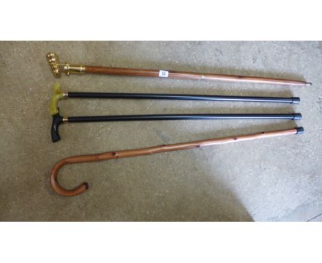 A brass handle walking stick with telescope in handle plus three other walking sticks 