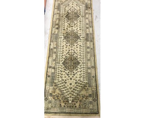 A Tabriz style runner, the central panel set with three repeating medallions on a cream ground, with stylised flower head and