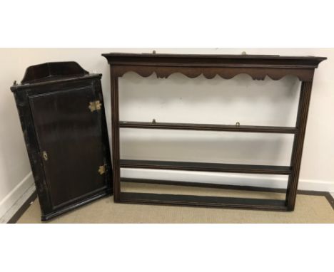 An 18th Century oak hanging corner cupboard with galleried top, the single door enclosing three shaped shelves, 56 cm wide x 