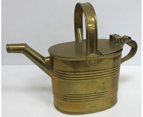 A collection of three brass watering cans/hot water jugs together with a pewter twin handled bowl bearing armorial to front w