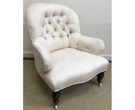 A 19th Century button back salon chair, raised on turned and ringed front legs to brass caps and china castors, 80 cm high