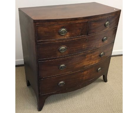 An early 19th Century mahogany bow fronted chest of two short over three long graduated drawers with brass handles, raised on