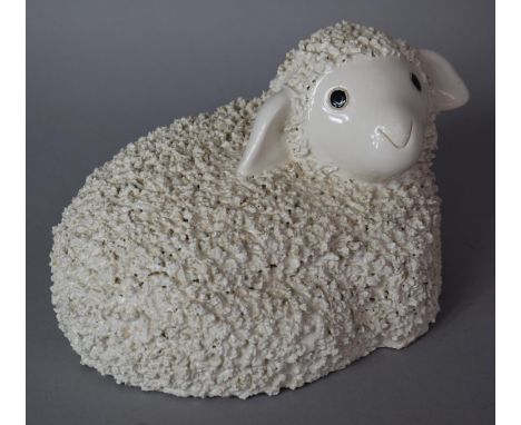 A White Glazed Ceramic Study of a Reclining Lamb, 29cm wide 