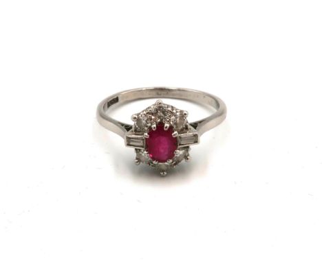 An Art Deco, Platinum diamond and ruby dress ring, with central oval cut ruby of approximately 5.9 by 4.2mm, with baguette cu