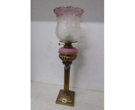 A brass oil lamp and shade