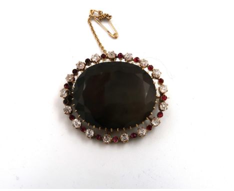 A Victorian diamond, ruby and moss agate brooch, the large, dark, oval cut moss agate of approximately 30.8 by 25.5mm, surrou