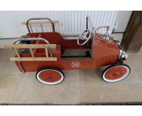 A child's tin plate pedal ride on toy fire engine, length 95cm - in very good condition for age - being sold on behalf of Eas
