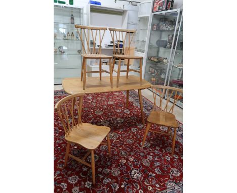 An Ercol dining table - 137cm x 70cm - and four Ercol dining chairs model 376 - in used but good condition
