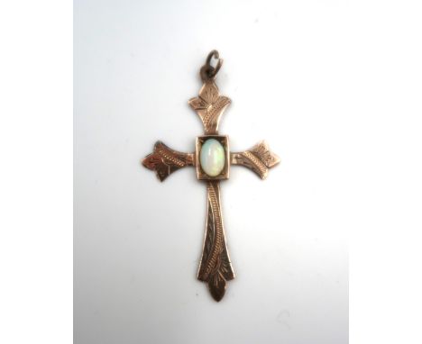 A Victorian gothic style cross pendant set with an oval white opal. Tests gold 9ct. Weight 1.43 grams