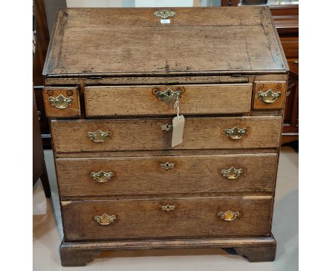 A Georgian oak fall front bureau with stepped and fitted interior, 4 drawers with brass swan neck handles and cut backplates,