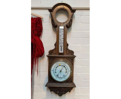 An Edwardian clock/barometer with thermometer in carved oak case, height 96 cm (clock missing) 