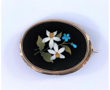 A vintage Pietra-Dora brooch showing blue and white flowers in a plain oval surround testing 9ct 