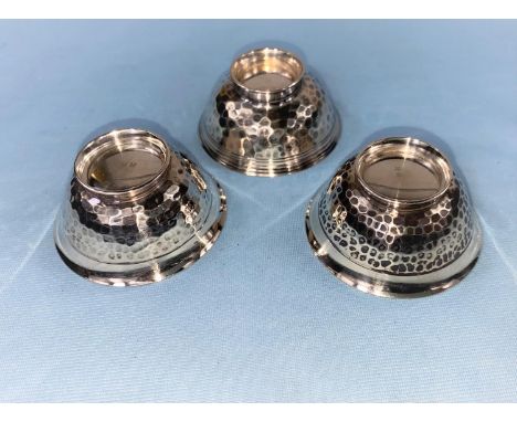 Three Japanese white metal sake cups with hammered details to the outside and a gilded interior, all with Kanji marks to base