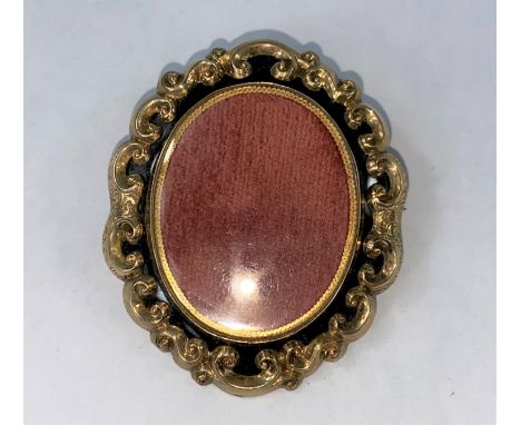 A Victorian double sided mourning brooch with black enamel and rococo gilt surround, height 5.5cm 