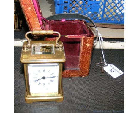 A small brass travelling carriage clock with leather case - 10cm