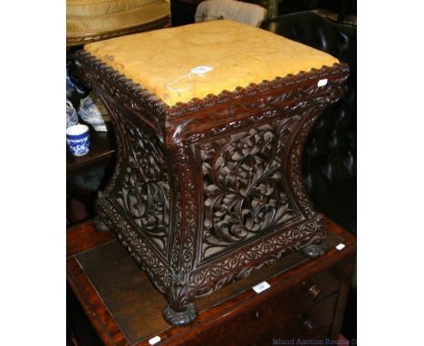 A 19th century carved wooden stool on bun feet