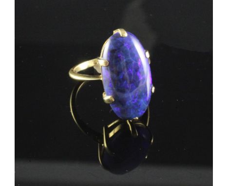 A gold and black opal ring, of good colour, the oval stone measuring approximately 20mm in length, size O.