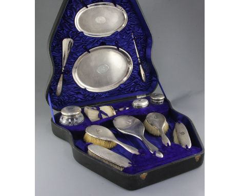 A cased George V thirteen piece engine turned silver dressing table set by Charles & Richard Comyns, comprising six brushes, 