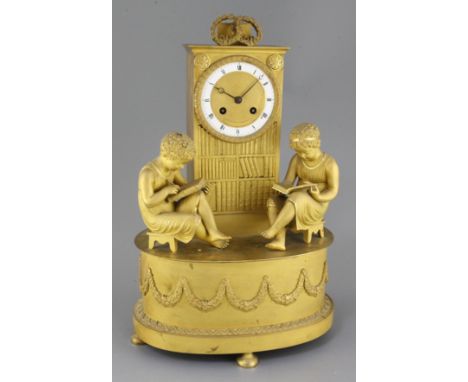 A French Empire ormolu mantel clock, modelled as a bookcase flanked by two children reading books, white enamelled Roman dial
