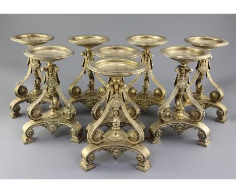A set of eight Victorian gilt metal comport stands by Cartwright & Woodward, of tripod form, with beaded scrolling stems deco
