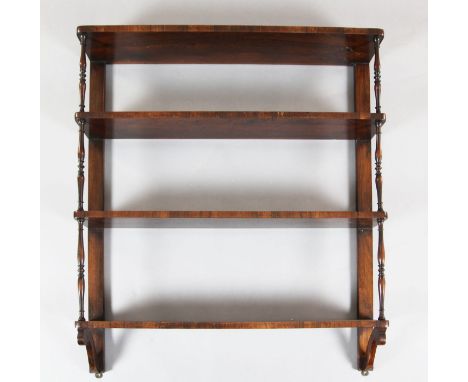 A Regency rosewood four tier wall shelf, with ring turned spindles, W.2ft 9in. D.6in. H.3ft 3in.